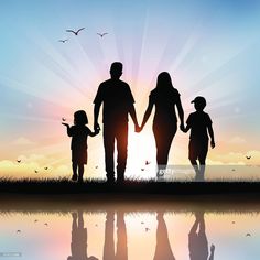 the silhouette of a family holding hands and walking across a body of water at sunset