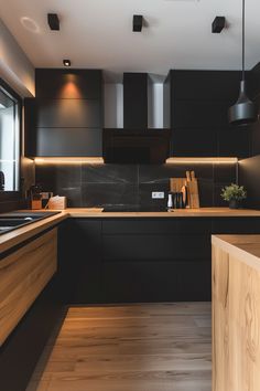 a modern kitchen with black cabinets and wood flooring on the countertops, along with an island in the middle