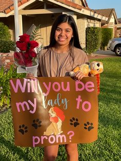 a girl holding a sign that says will you be my lady to prom? with her dog