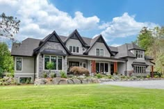 a large house with lots of windows in the front yard and landscaping on both sides