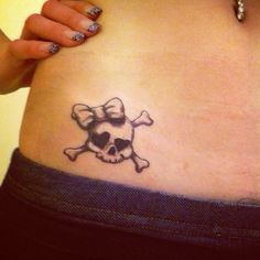 a woman's stomach with a skull and crossbones tattoo on her belly