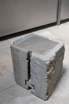 a concrete block sitting on top of a tiled floor