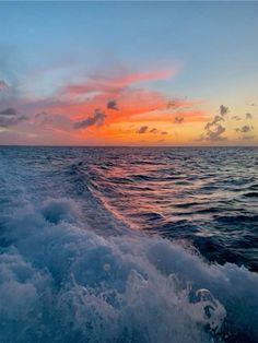 the sun is setting over the ocean as seen from a boat