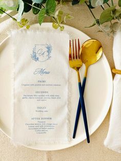 a white plate topped with two forks and a menu on top of a table next to flowers