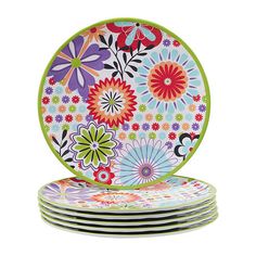 four colorful plates stacked on top of each other in front of a white background with flowers