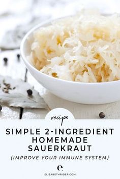 a white bowl filled with sauerkraut on top of a wooden table next to leaves