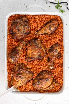 a casserole dish with chicken and carrots in it on a white surface