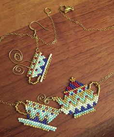 three pieces of beaded jewelry sitting on top of a wooden table