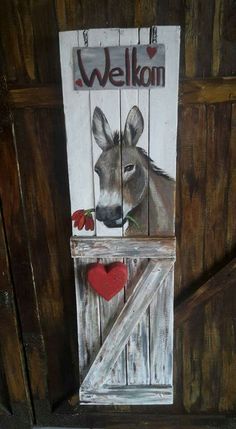 a painting of a donkey sticking its head out of a barn door with the word welcome painted on it