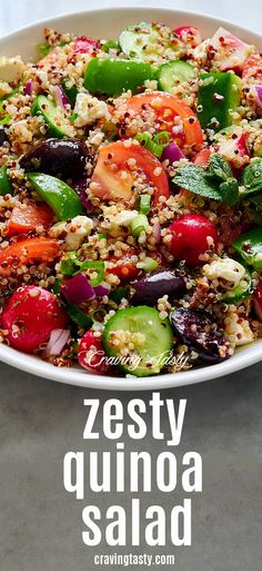 a white bowl filled with lots of veggies and quinoa salad on top of a table