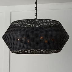 a black wicker light hanging from a ceiling in a room next to a door