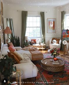 a living room filled with lots of furniture and decor on top of a wooden floor