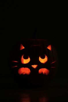 a carved pumpkin with glowing eyes in the dark