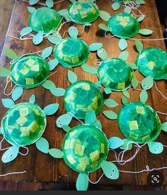 some paper plates with turtles on them and string attached to the sides, sitting on a wooden table