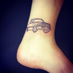 a black and white photo of a foot with a truck tattoo on it's side