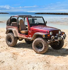 a jeep is parked on the beach by the water