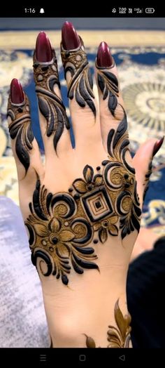 a woman's hand with henna tattoos on it