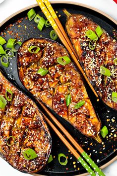 two pieces of food on a plate with chopsticks