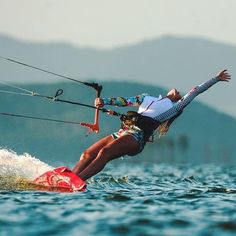 a woman riding on top of a surfboard while holding onto a handle attached to a rope