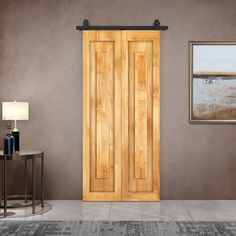 an empty room with a wooden door and two pictures hanging on the wall next to it