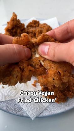 a person is holding some food in their hand with the caption crispy vegan fried chicken