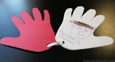 two handprints are on top of each other and one has a name tag attached to it