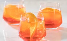 three glasses filled with liquid and orange slices