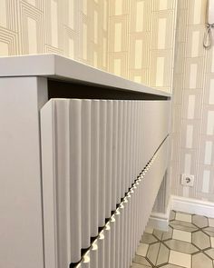 a white radiator with some lights on it in a room next to a tiled floor