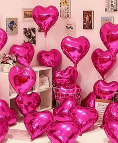 many pink heart shaped balloons in a room