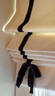 a stack of folded white sheets with black ribbon