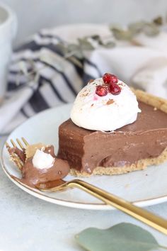 a piece of chocolate pie with whipped cream and cherries on top, sitting on a plate