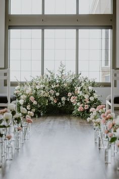 the aisle is lined with white and pink flowers