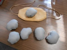 four pieces of felt sitting on top of a wooden table next to a purse and other items