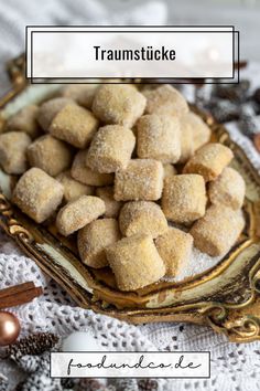 a plate filled with sugared donuts sitting on top of a white table cloth