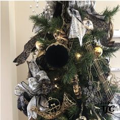 a christmas tree decorated with black and white ribbon, ornaments, and ribbons on it