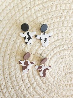 "Clay Cow Dangle Earrings. Choose from black or brown.  Handmade with a bit Of Hope and Clay, these earrings are perfectly imperfect, as each pair of earrings is uniquely made.  Message me about custom and/or bulk orders!  *All metal findings and posts on earrings are made from nickel free stainless steel or plated brass (or sterling silver if applicable). *Even though \"nickel free\" jewelry is labeled hypoallergenic I cannot promise 100% hypoallergenic materials due people having different levels of sensitivity to different materials. *Colors of actual product may differ slightly from listing pictures. I do my best to capture the actual color of the product in the listing photos. *Because they are handmade some minor imperfections and differences may apply, but that's what makes them uni Trendy Hypoallergenic Brown Earrings, Trendy Brown Hypoallergenic Earrings, Trendy Hypoallergenic Earrings, Clay Cow, Cow Earrings, Brown Cow, Nickel Free Jewelry, Black Cow, Tucson Az