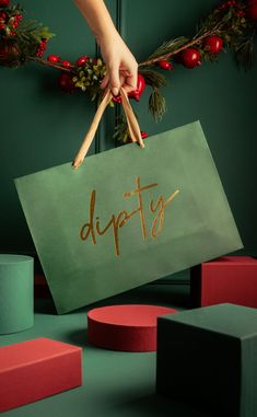 a person holding a sign with the word dipty written on it in gold foil