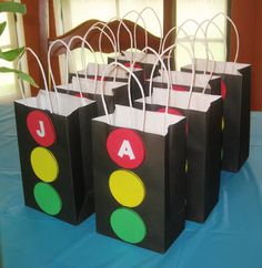 small black bags with letters on them sitting on a blue table cloth covered tablecloth