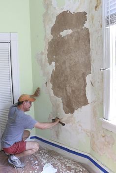 a man is painting the walls in an empty room