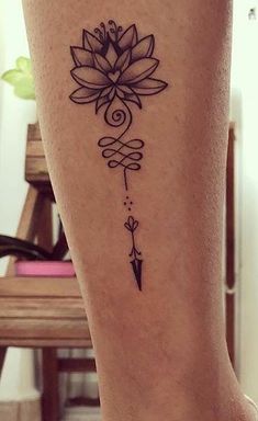 a woman's foot with a flower tattoo on the ankle and an arrow in the middle