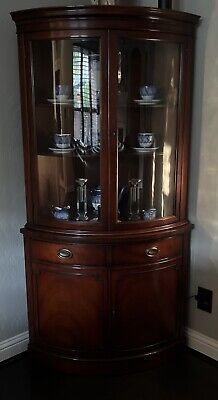 a large wooden china cabinet with glass doors