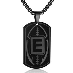 a black dog tag with the letter e on it and a football ball in the center