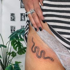 a woman with a snake tattoo on her lower leg and the word boo written in cursive writing