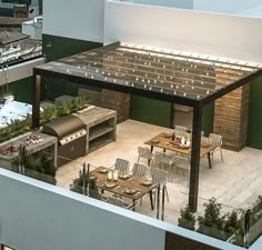 an outdoor dining area on the roof of a building with tables, chairs and grill