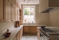 a kitchen with wooden cabinets and white counter tops next to an open stove top oven