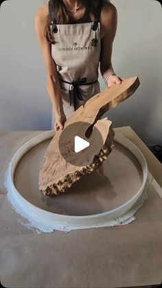 a woman in an apron is making a piece of wood with a circular sawtooth