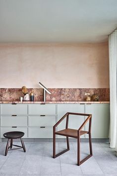 a chair sitting in front of a counter next to a window