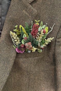 a man wearing a suit and tie with flowers in his lapel flower arrangement on the lapel