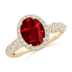 an oval shaped ruby and diamond ring in yellow gold with diamonds around the shans