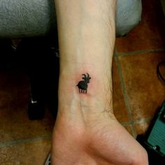 a small elephant tattoo on the wrist is shown in black ink, and it appears to be tiny